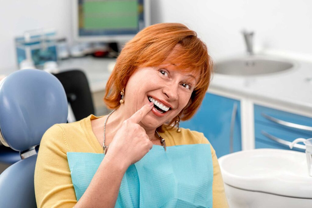 woman pointing to her teeth that had been finished