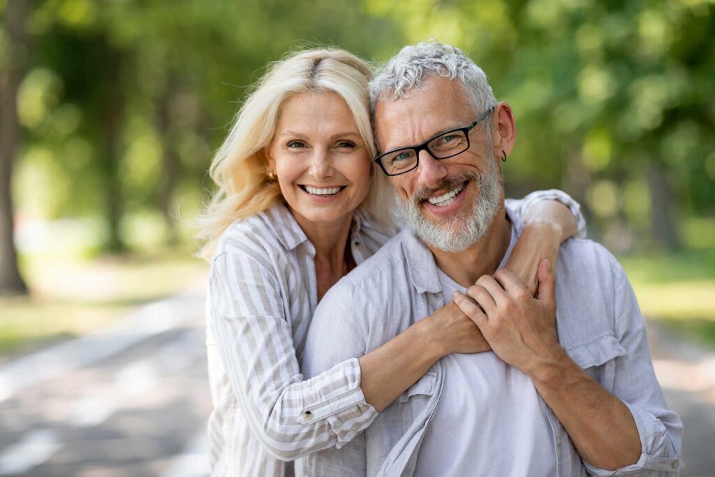 a senior couple smiling in a park